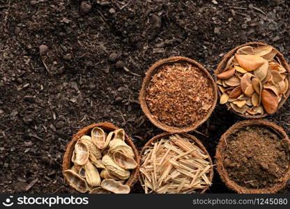 Pea shell, manure, dry leaves, dry grass and sawdust, put in a cup, placed on the ground, the concept of soil degradation.