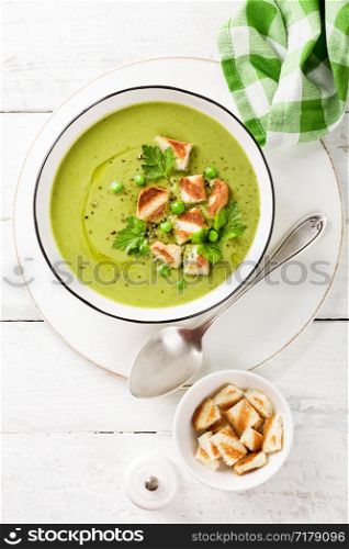 Pea soup. Green pea puree soup in a bowl served with grilled toasts, top view