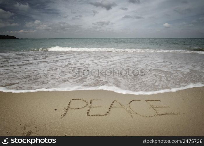 Peace word on sea sandy shore. Nature conceptaul composition.