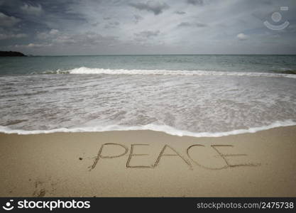 Peace word on sea sandy shore. Nature conceptaul composition.