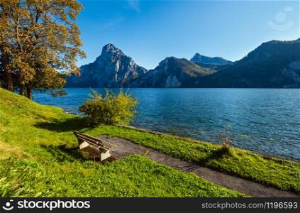 Peaceful autumn Alps mountain lake and resting place. Morning view to Traunsee lake and Traunstein mountain in far, Upper Austria.