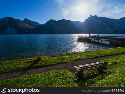 Peaceful autumn Alps mountain lake. Morning view to Traunsee lake and Traunstein mountain in far, Upper Austria. People unrecognizable.