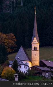 Peaceful autumn night Alps mountain countryside church on Gosau village outskirts near forest, Austria.