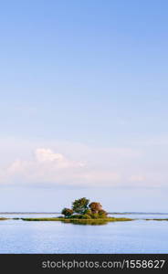 Peaceful calm lake and small island with tropical tree at Nong Han Sakon Nakhon - Thailand.