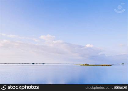 Peaceful calm lake with blue sky and small flat island at Nong Han Sakon Nakhon - Thailand.