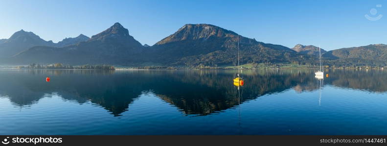 Peaceful mountain lake with clear transparent water and reflections. Autumn Wolfgangsee lake panorama, St. Wolfgang im Salzkammergut, Upper Austria.