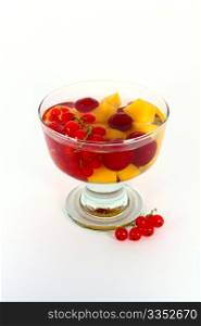 Peach compote with fresh red currants in glass bowl isolated on white