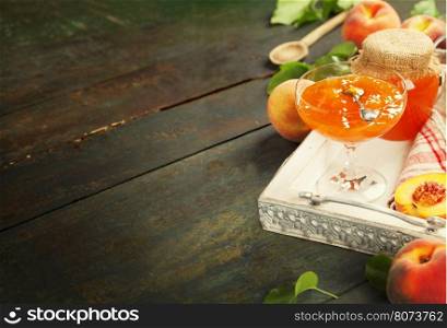 Peach jam with fresh peaches on rustic table. Homemade bio food concept