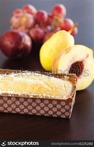 peach, pear, plum, coconut cake and grapes on a wooden table