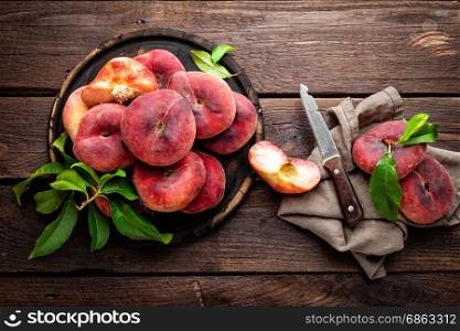 Peach, saturn or donut peaches with leaves