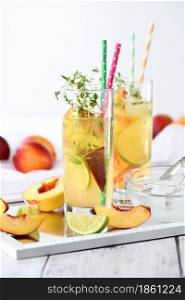 Peach summer cocktail. Refreshing organic non-alcoholic drink, lemonade with ripe nectarine, thyme and lime