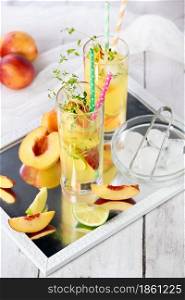 Peach summer cocktail. Refreshing organic non-alcoholic drink, lemonade with ripe nectarine, thyme and lime