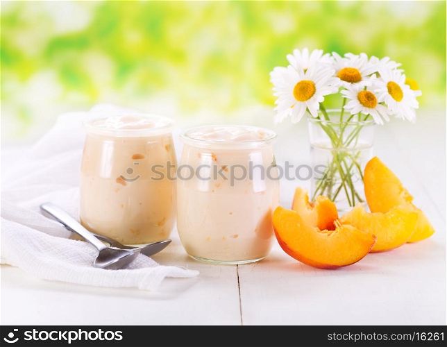 peach yogurt with fresh fruits on wooden table