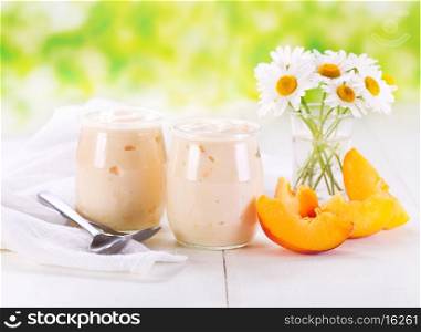 peach yogurt with fresh fruits on wooden table