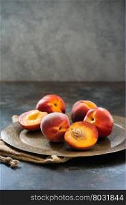 Peaches and nectarines on vintage tray over dark background, selective focus
