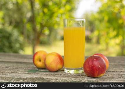 peaches and peach juice on a wooden table, outdoor