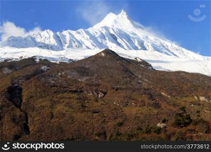 Peak of Manaslu with snow and forest in Nepal