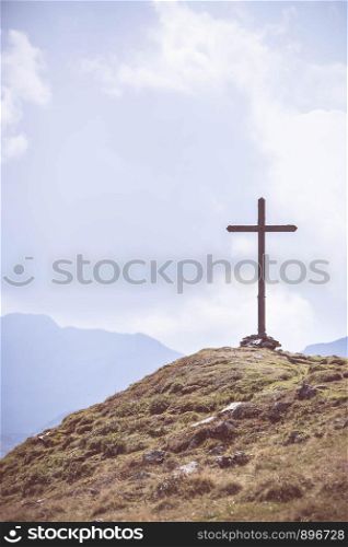 Peak with wooden summit cross in the Austrian mountains