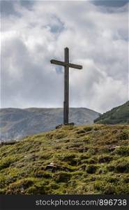 Peak with wooden summit cross in the Austrian mountains