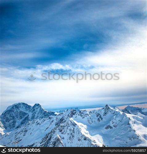 Peaks of blue mountains in snow. Winter natural landscape