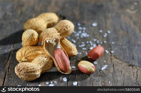 peanut and salt isolated on wooden background