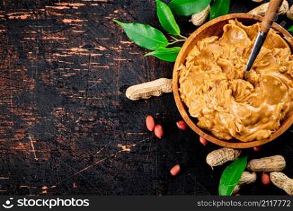 Peanut butter on a plate with a spoon. Against a dark background. High quality photo. Peanut butter on a plate with a spoon.