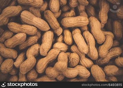 Peanuts background, tasty high-calorie nuts, monkey nuts in the nutshell, abstract groundnuts wallpaper. Peanuts background
