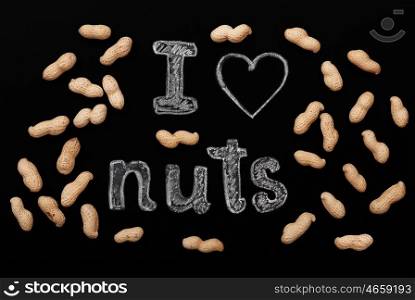 "Peanuts on a black background and chalk inscription "I love nuts""