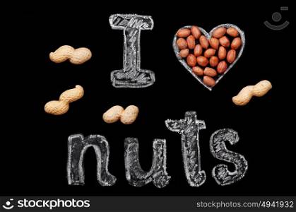 "Peanuts on a black background and chalk inscription "I love nuts""