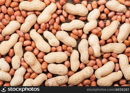 Peanuts scattered on a wooden table. Background with nuts.