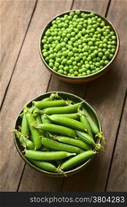 Peapods (lat. Pisum sativum) and peas in bowls (Selective Focus, Focus into the middle of the peapods)