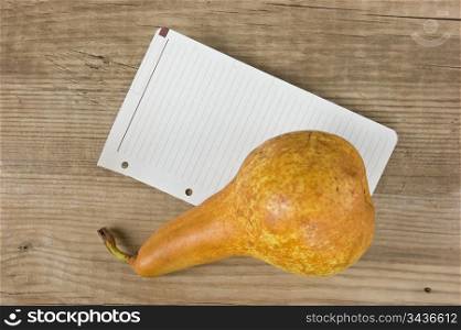 pear and a note on a wooden background