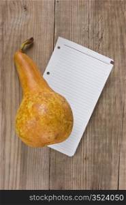 pear and a note on a wooden background