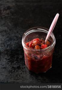Pear cranberry relish for Christmas in jar over dark background, copy space