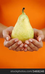 pear in woman hands close up