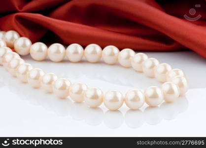 Pearls necklace on satin background