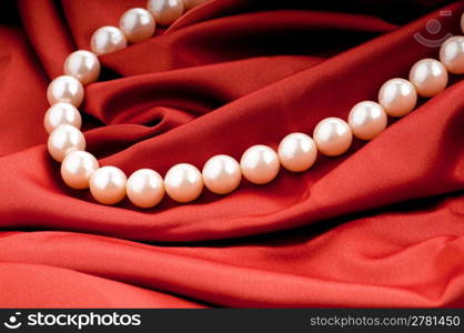 Pearls necklace on satin background