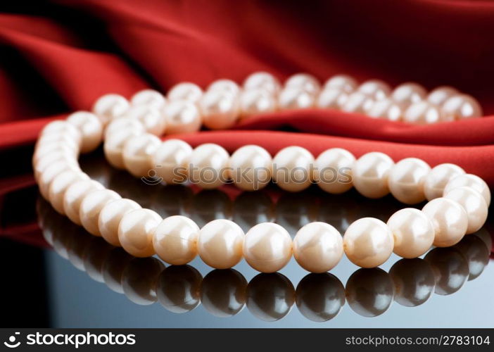 Pearls necklace on satin background