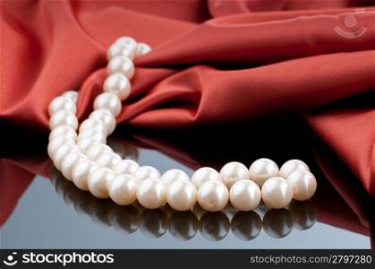 Pearls necklace on satin background