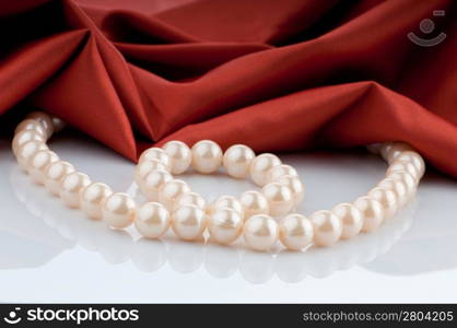 Pearls necklace on satin background