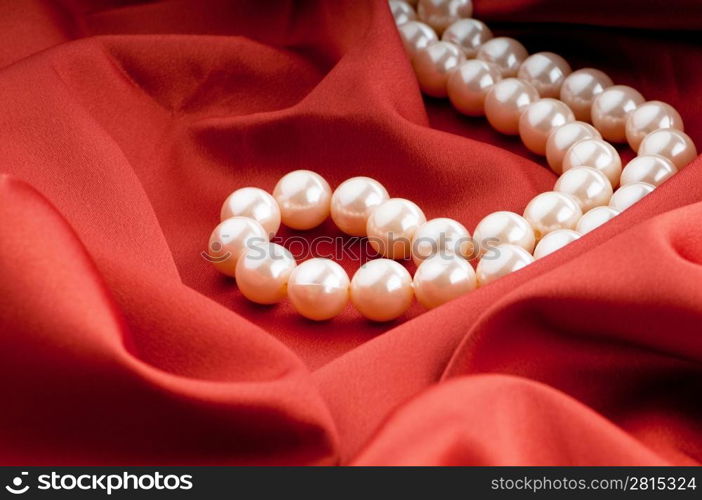 Pearls necklace on satin background