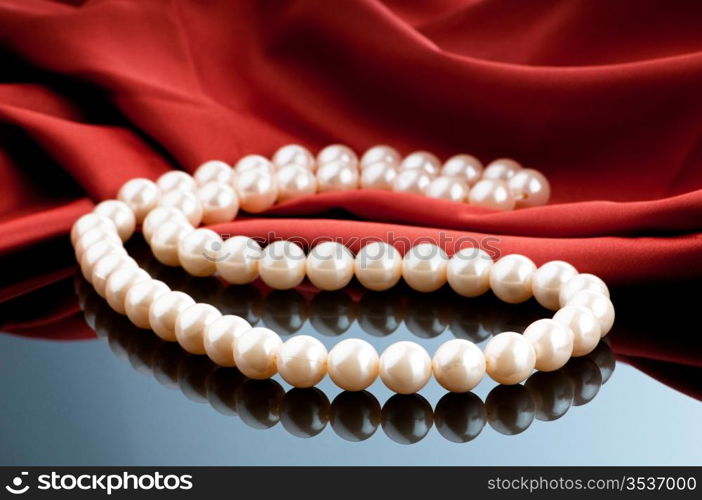 Pearls necklace on satin background