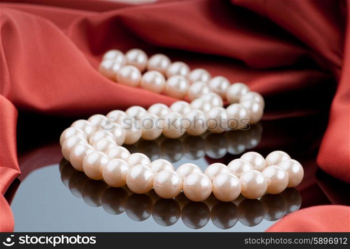 Pearls necklace on satin background