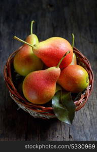 Pears in a basket on wooden table