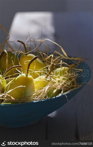 Pears in blue basket and natural sunlight