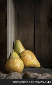Pears in rustic setting with wooden box and hessian sack