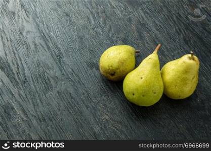 Pears on a black wooden background, healthy food. Pears on wooden background