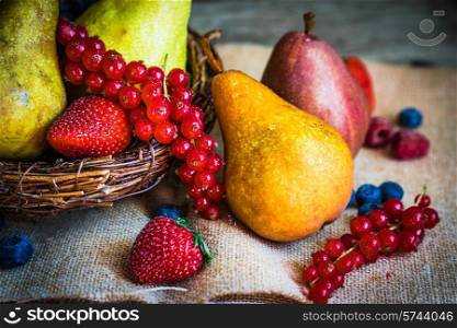 Pears with berries on wooden background