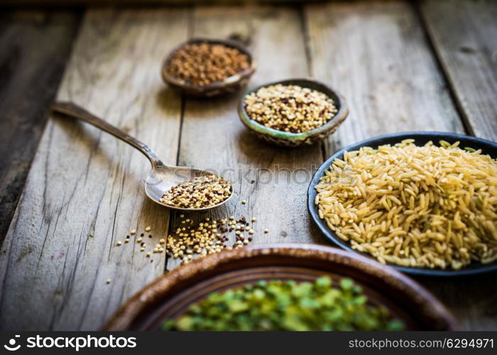 Peas,brown rice,quinoa and buckwheat on wooden background