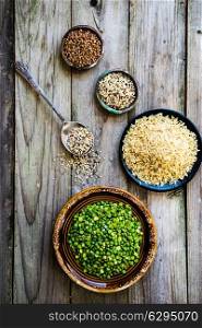 Peas,brown rice,quinoa and buckwheat on wooden background